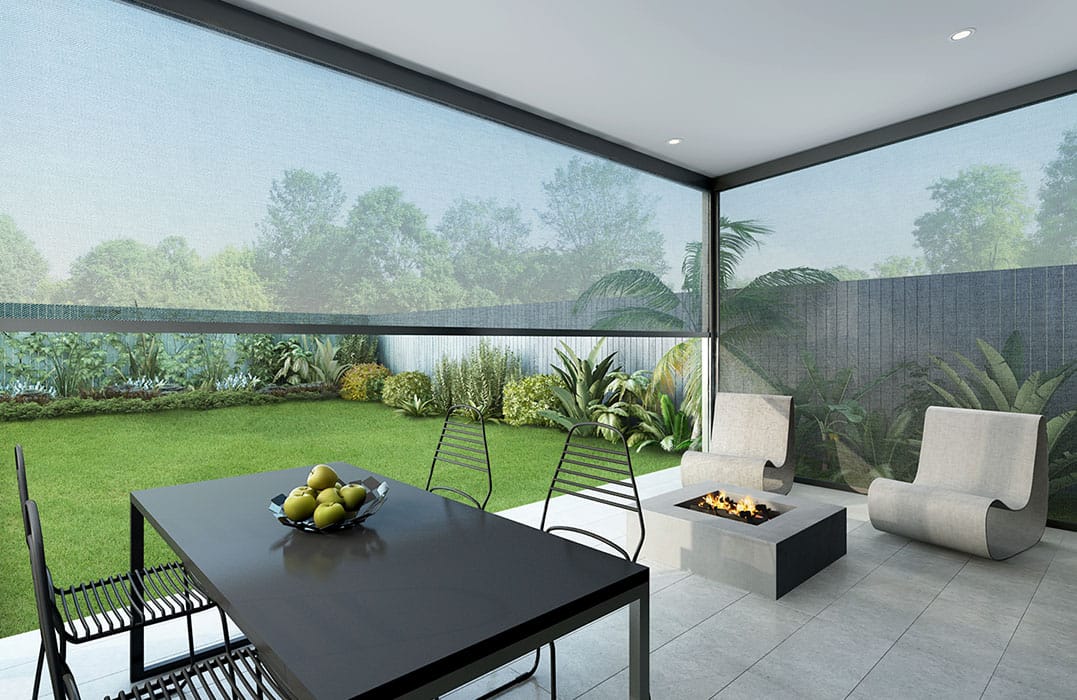 Modern covered patio with a black dining table, metal chairs, two curved lounge chairs, and a rectangular fire pit, overlooking a landscaped garden.